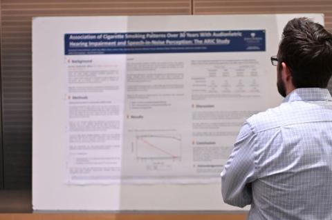 A man studies a research poster. 