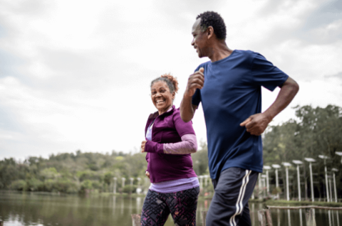 Two older adults jog together